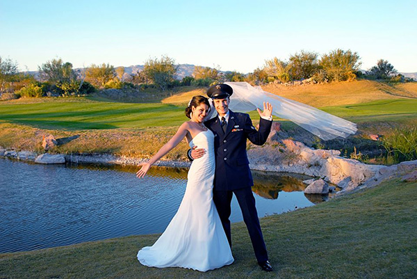 bride and groom holding each other in front of lake