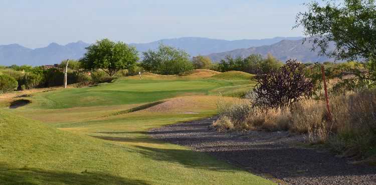 view of the fairway leading to the green, with the mountains in the background