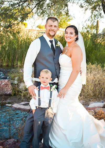bride and groom with child posing for photo