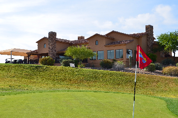 green with flag and clubhouse in the background